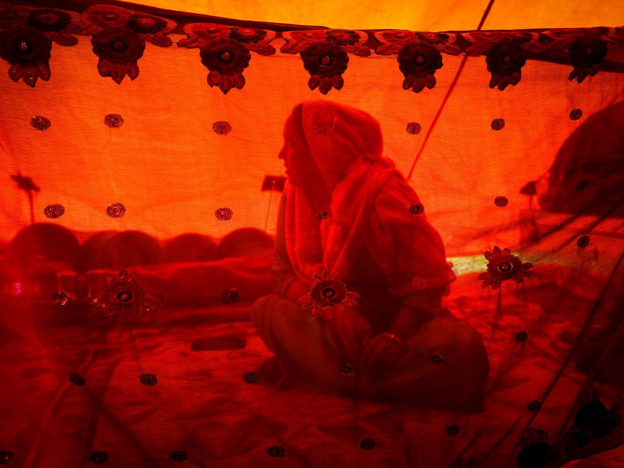 Razia, 35, a member of the Bakarwal tribal community, in her tent. She had travelled for days and has had bad experiences of travelling during her menstruation. The 200-kilometre journey takes a month and involves trekking through high mountain passes populated by potentially dangerous wild animals. Date: 27 April, 2022.