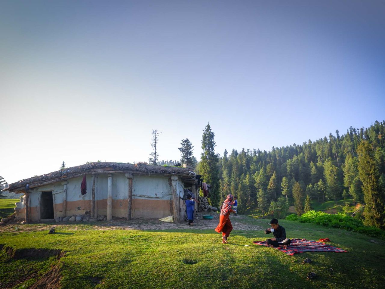 Children from a Gujjar family playing and having tea outside their mud-built house near Yousmarg, Kashmir around 50 kms away from the capital of Srinagar. Date: 11 May, 2022.
