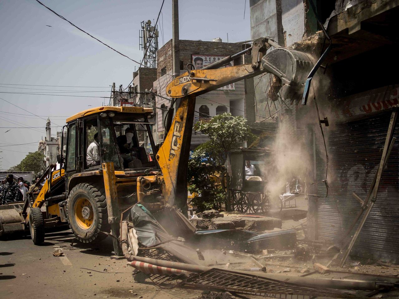Bulldozers raze structures during a demolition drive against encroachment at a communal clash affected neighbourhood in Jahangir Puri in New Delhi on April 20, 2022. Bulldozers continued razing property for nearly two hours after India's chief justice issued an order to halt.