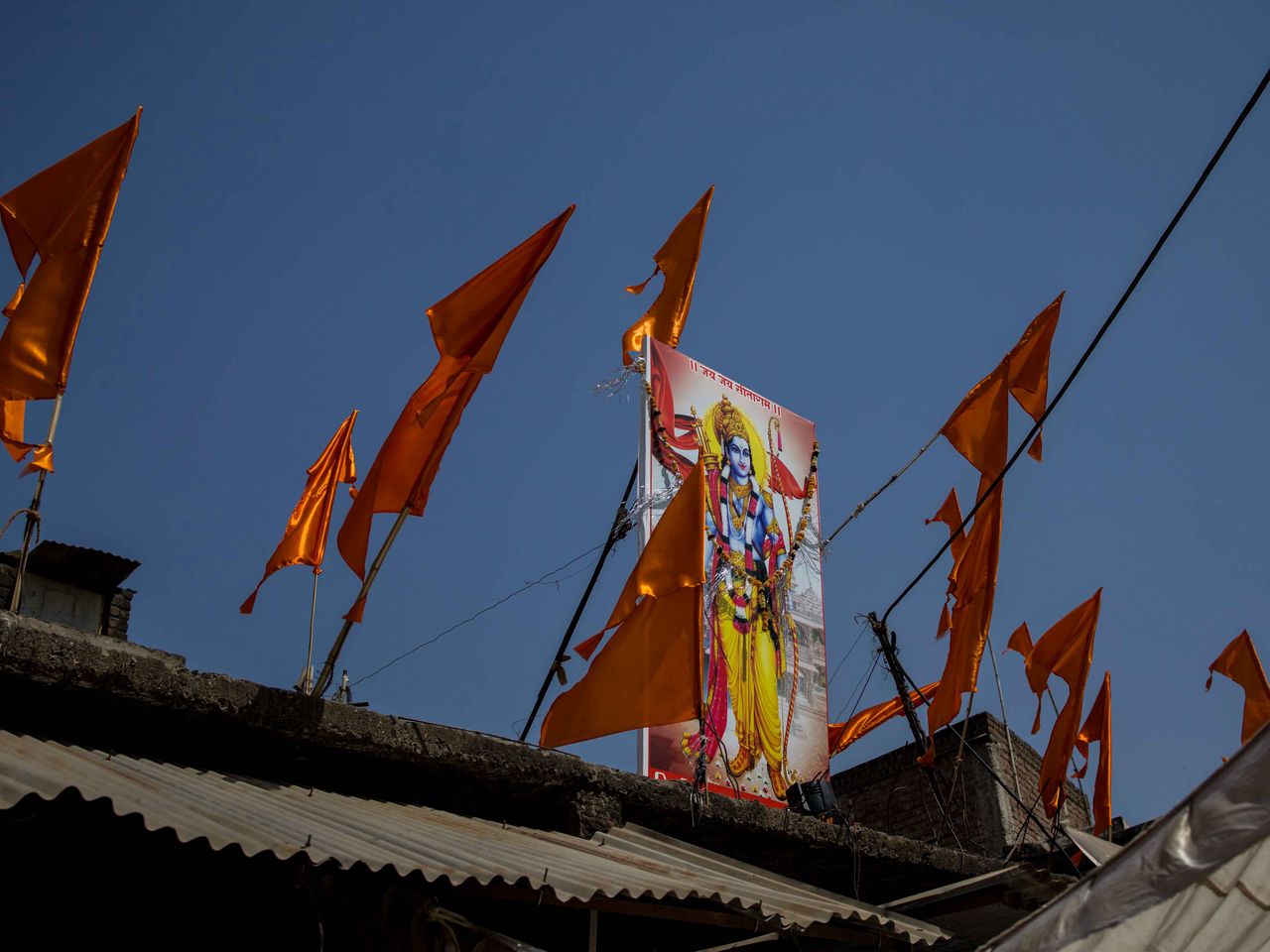 A poster of Hindu deity lord Rama pictured with saffron flags at the site where communal clashes took place during a Hindu religious procession at Talaab Chowk in Khargone in India's Madhya Pradesh state on April 15, 2022. As a national campaign by right-wing groups inflames local tensions, Muslim communities are facing the harshest punishments, according to activists, analysts and retired officials.